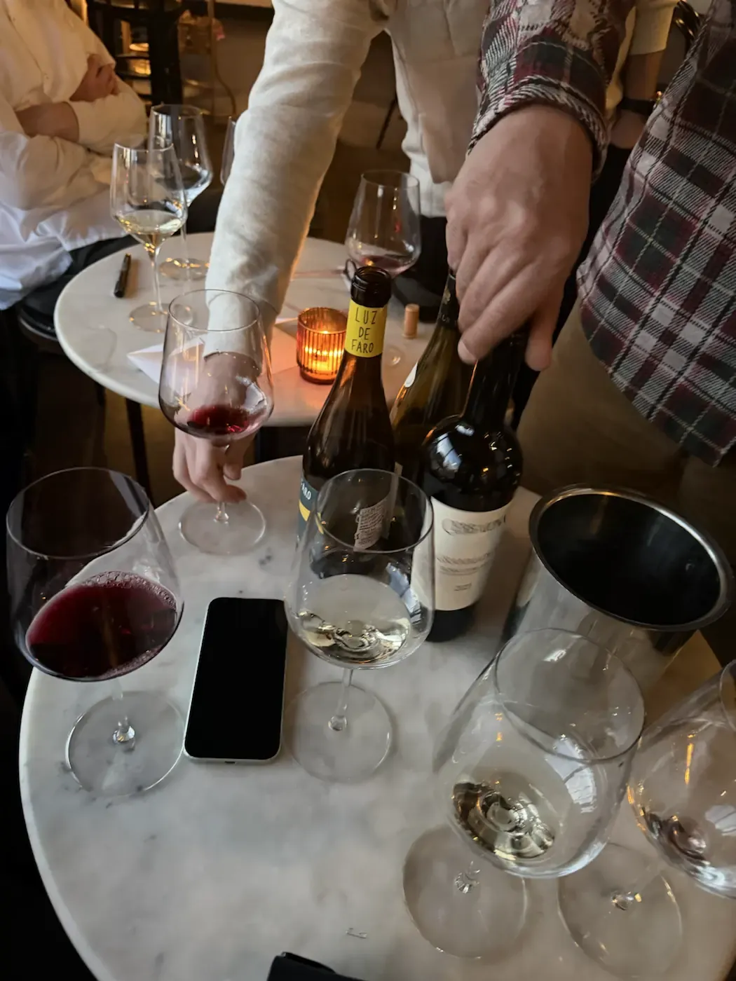 Guests sharing wine around a candlelit table at Roto All Day